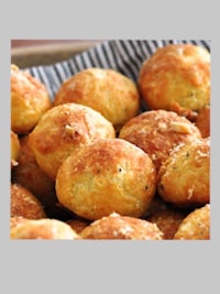 a bowl of bread rolls with parmesan cheese on top
