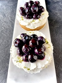 a blueberry tart with mint leaves on top