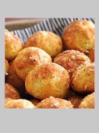 a bowl of bread rolls with parmesan cheese in it
