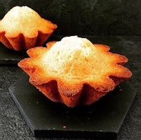 two muffins sitting on top of a black surface